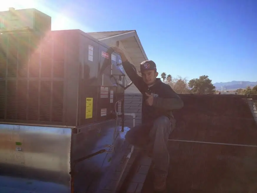 HVAC technician performing Air Duct Repair on a rooftop unit in Hastings